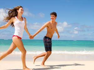 Парень и девушка бегут по пляжу